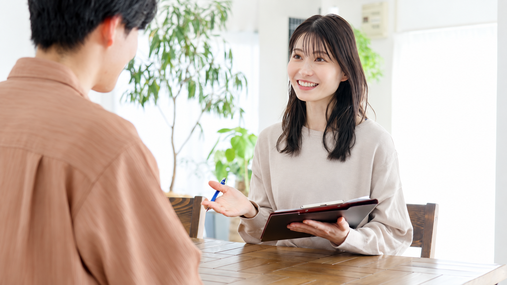 女性カウンセラーと対面で話す男性